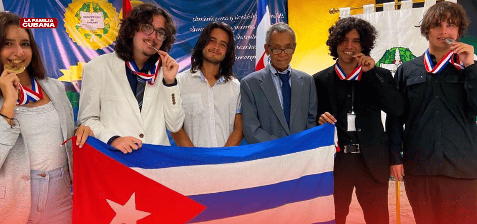 estudiantes cubanos mostrando sus medallas en la olimipada de quimica y posando con la bandera cubana